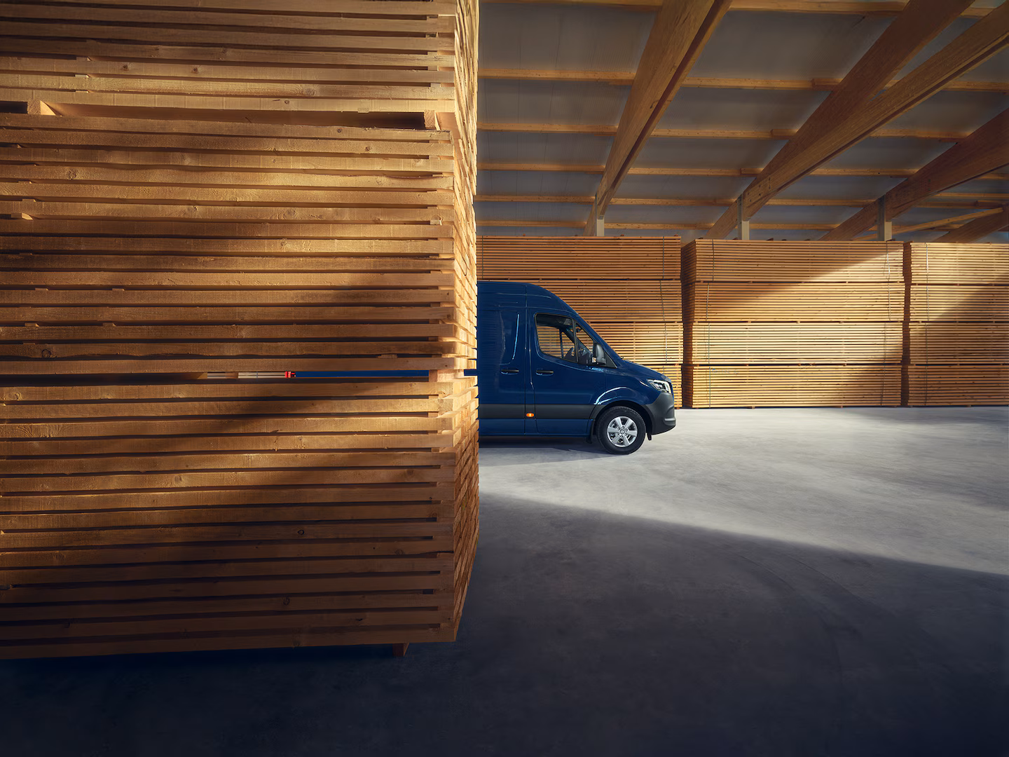 eSprinter blau vor Holzpaletten