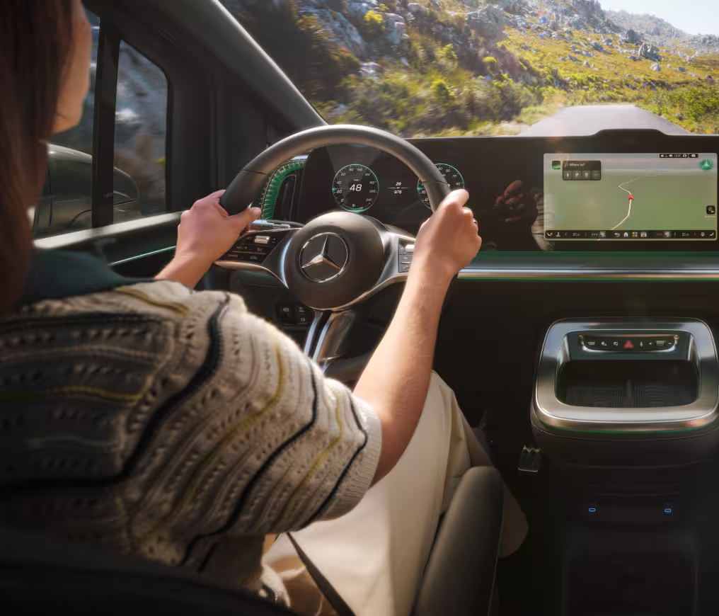 Mercedes Benz VLE 2026 - Frau fährt Auto, hält Hände am Lenkrad, Innenraum zu sehen