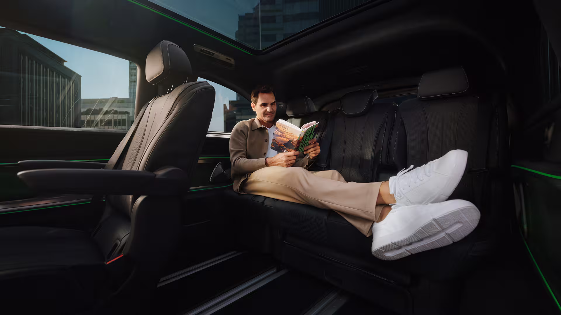 Mercedes Benz VLE 2026 - Mann sitzt im Auto auf der Rückbank und liest ein Buch